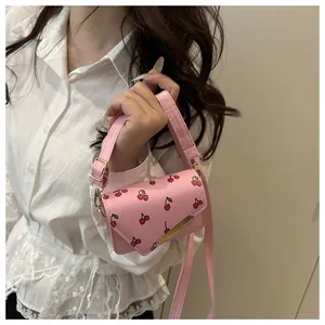 Detail van roze mini-crossbodytas met kersenprint en gouden metalen gesp