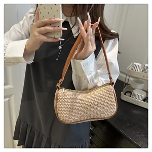 Makro-Detail der handgewebten Strohstruktur und braunem Lederbesatz der Sommer-Schultertasche