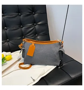 Nahaufnahme der Canvas-Schultertasche mit braunem Kunstlederbesatz und Seitentaschen