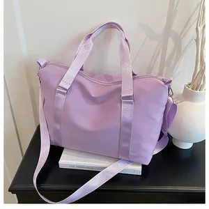Dettaglio borsa da viaggio in nylon viola con tracolla regolabile e finiture in argento