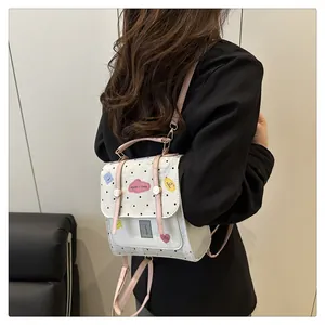 Detailansicht eines weißen Mini-Rucksacks mit rosa Gurten und süßen Cartoon-Aufnähern
