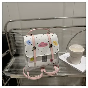 Detail eines weißen Polka-Dot-Mini-Rucksacks mit rosa Riemen und süßen Comic-Sticker-Prints
