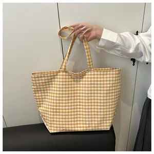 Detail of yellow gingham canvas tote bag with large capacity and dual shoulder straps