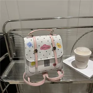 Mini-Rucksack in Rosa und Weiß mit Punkten und bunten Patches auf Metallregal