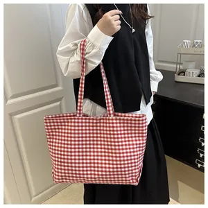 Detailed view of classic red and white checkered canvas tote bag with wide straps