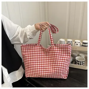 Close-up of red and white gingham canvas tote bag with thick fabric texture and handles