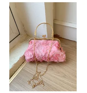 Detalle de bolso de noche rosa con rosas de tela 3D y correa de cadena de metal dorado