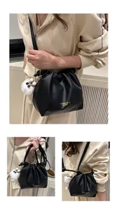Detalle del bolso nube negro plisado con colgante de peluche y letras de moda