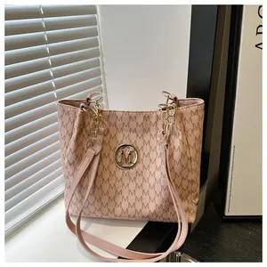 Détail du sac cabas rose à monogramme avec logo M doré et bandoulière en chaîne