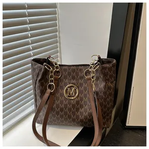 Détail du sac cabas marron vintage avec monogramme M et boucle en métal doré