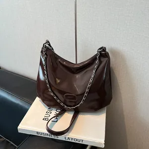 Détail du sac hobo en cuir verni marron chocolat brillant avec chaîne et bandoulière