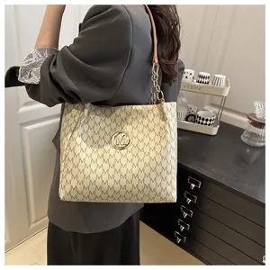 Gros plan détaillé d'un sac demi-lune monogramme avec logo doré et chaîne élégante