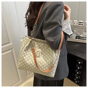 Détail du sac cabas en cuir souple avec motif M et anse en chaîne métallique dorée