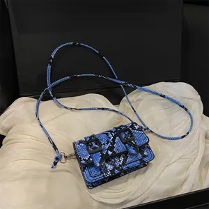 Mini borsa a tracolla chic con motivo a serpente blu e nero e doppie fibbie su tessuto