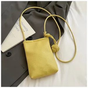 Dettaglio della mini borsa a tracolla gialla con cinturino a corda e nodo decorativo