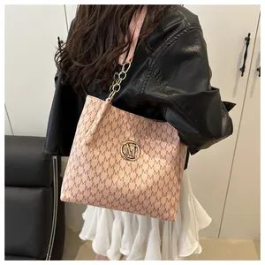 Détail du sac cabas rose avec imprimé monogramme M et bandoulière en chaîne dorée