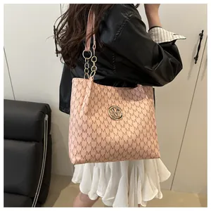 Détail du sac cabas rose avec motif jacquard à lettres M et bandoulière chaîne dorée