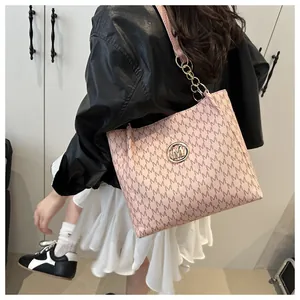 Détail du cabas rose à monogramme avec bandoulière en chaîne dorée et boucle M