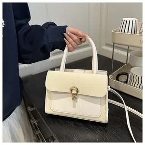 Close-up of woven texture and golden horseshoe buckle on cream crossbody bag
