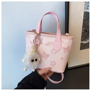 Close-up of pink bucket bag with embossed cartoon patterns and plush charm