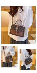 Detail view of vintage brown monogram bag featuring a golden horseshoe buckle and strap