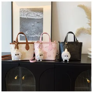 Three elegant embossed bucket bags in beige, pink, and black with plush monster charms