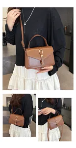 Detail view of the brown leather texture and elegant gold metal buckle on the crossbody bag