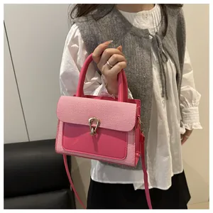 Detail of pink PU crossbody bag with woven texture flap and golden metal clasp on model