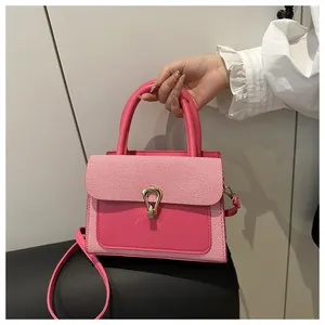 Detail of pink small square handbag with striped fabric flap and gold metal buckle