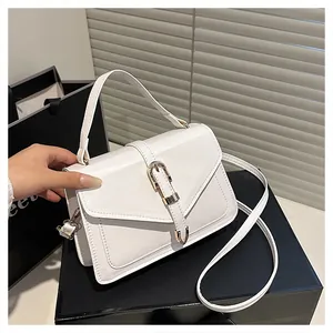 Detail of white crossbody bag with cross-grain texture and gold metal push buckle