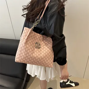 Sac à épaule en cuir rose avec motif M matelassé et logo doré porté par un mannequin