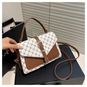 Detail of classic brown and white monogram canvas bag with leather strap and metal clasp