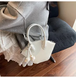 Sac à main blanc géométrique avec poignée à nœud en corde porté à l'épaule