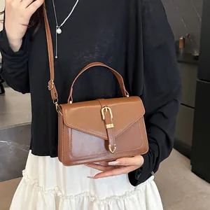 Brown minimalist square crossbody bag with V-stitch design and golden buckle detail