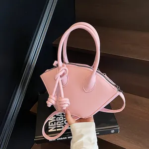Sac à main en cuir rose en forme d'éventail avec bandoulière à nœud sur marches