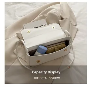 Capacity display of the white leather shoulder bag with dark interior for daily essentials