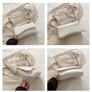 Detail of white PU leather shoulder bag with thick knot strap and gold metal accents