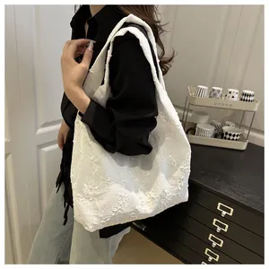 Detail of white chiffon tote bag featuring intricate 3D floral embroidery and lace texture
