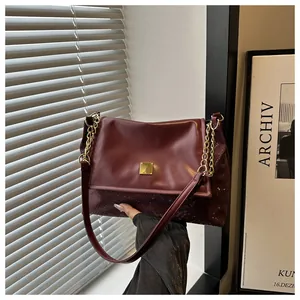 Elegant burgundy shoulder bag featuring snakeskin texture and gold metal buckle detail