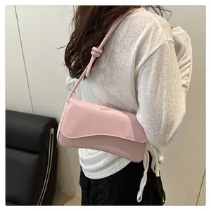 Detail view of pink shoulder bag with knotted strap on model for daily commuting
