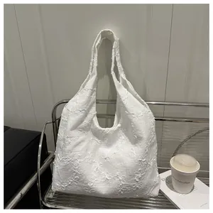 Close-up of white floral embroidery on a soft chiffon shopping tote shoulder bag