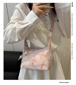 Détail du sac à main en dentelle rose avec papillons 3D et bandoulière réglable pratique