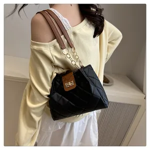 Detalle del bolso bandolera de paja acolchado negro con cadena dorada en modelo
