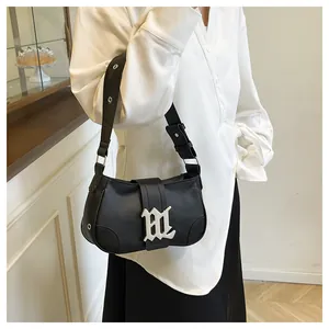 Detalle del bolso de hombro en cuero PU negro con hebilla artística plateada y remaches