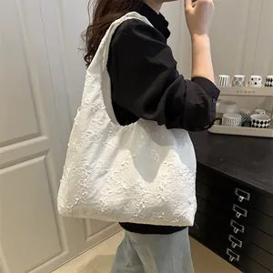 Fresh white floral embroidered tote bag for women showing large capacity on shoulder