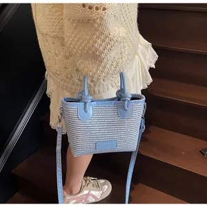 Detail of blue and white woven tote with knotted handle and fashion brand tag