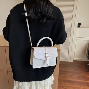 Fashionable white textured crossbody bag with top handle and snake pattern detail