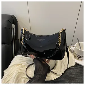 Detail of black patent leather handbag with gold chain and Fashion & Bags Est. 1985 text