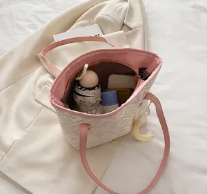 Detail showing high capacity tote bag with floral patterns holding daily essentials