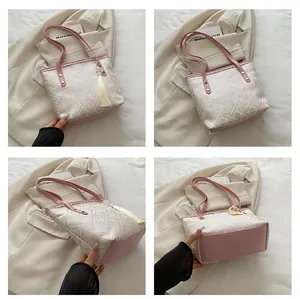 Detail view of pink leather handles and geometric jacquard fabric on a large tote bag